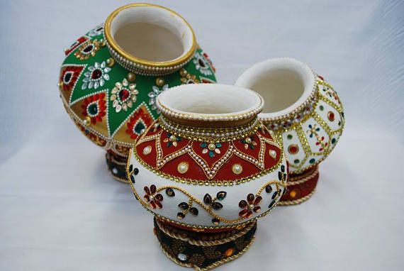 Pots painted with colors and decorated with colourful stones at a wedding